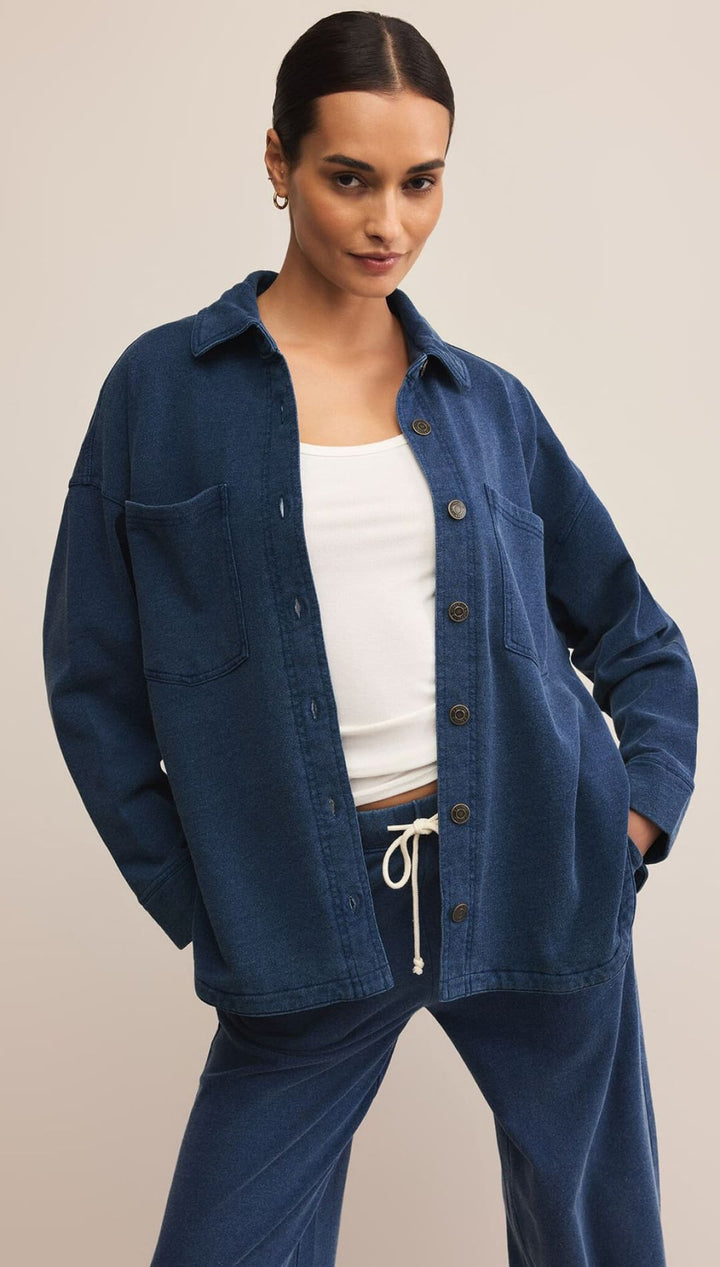 A woman modeling a dark blue button-up shirt and matching wide-leg pants with a white drawstring.