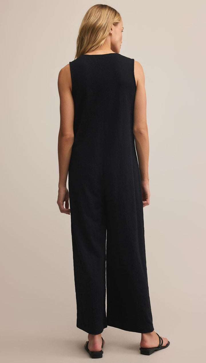 Black sleeveless jumpsuit with wide-leg design and button detail down the back.