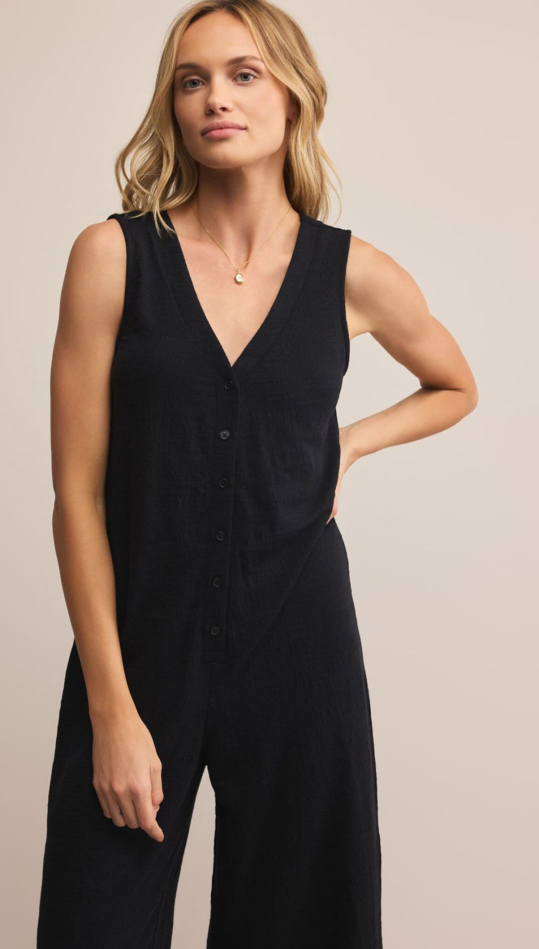 Black sleeveless jumpsuit with button-down front and wide-leg design.