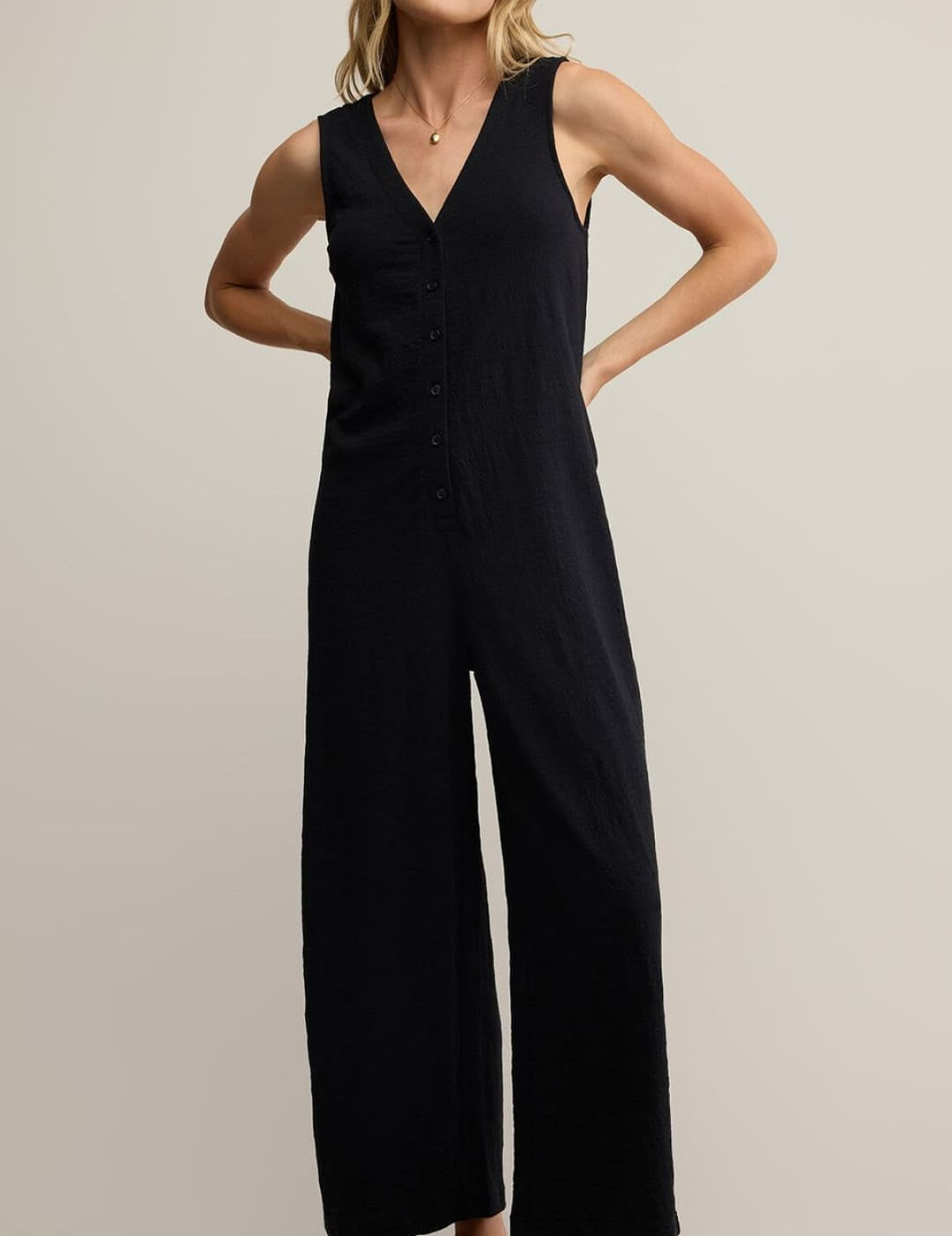 Black jumpsuit with wide-leg design and v-neckline, made of stretchy fabric.