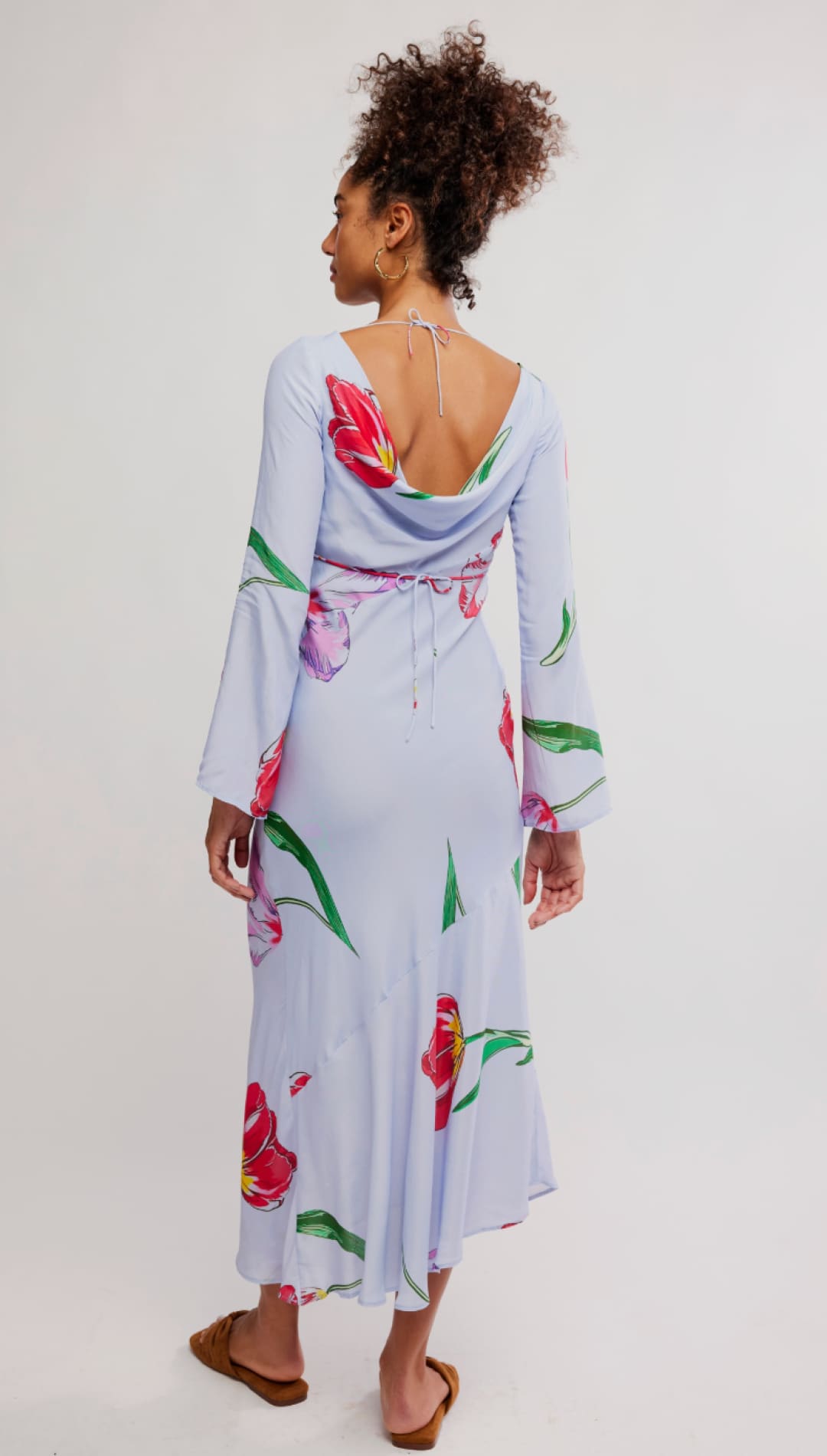 A flowing light blue midi dress adorned with vibrant red and pink tulip prints, featuring long bell sleeves and a back tie detail.
