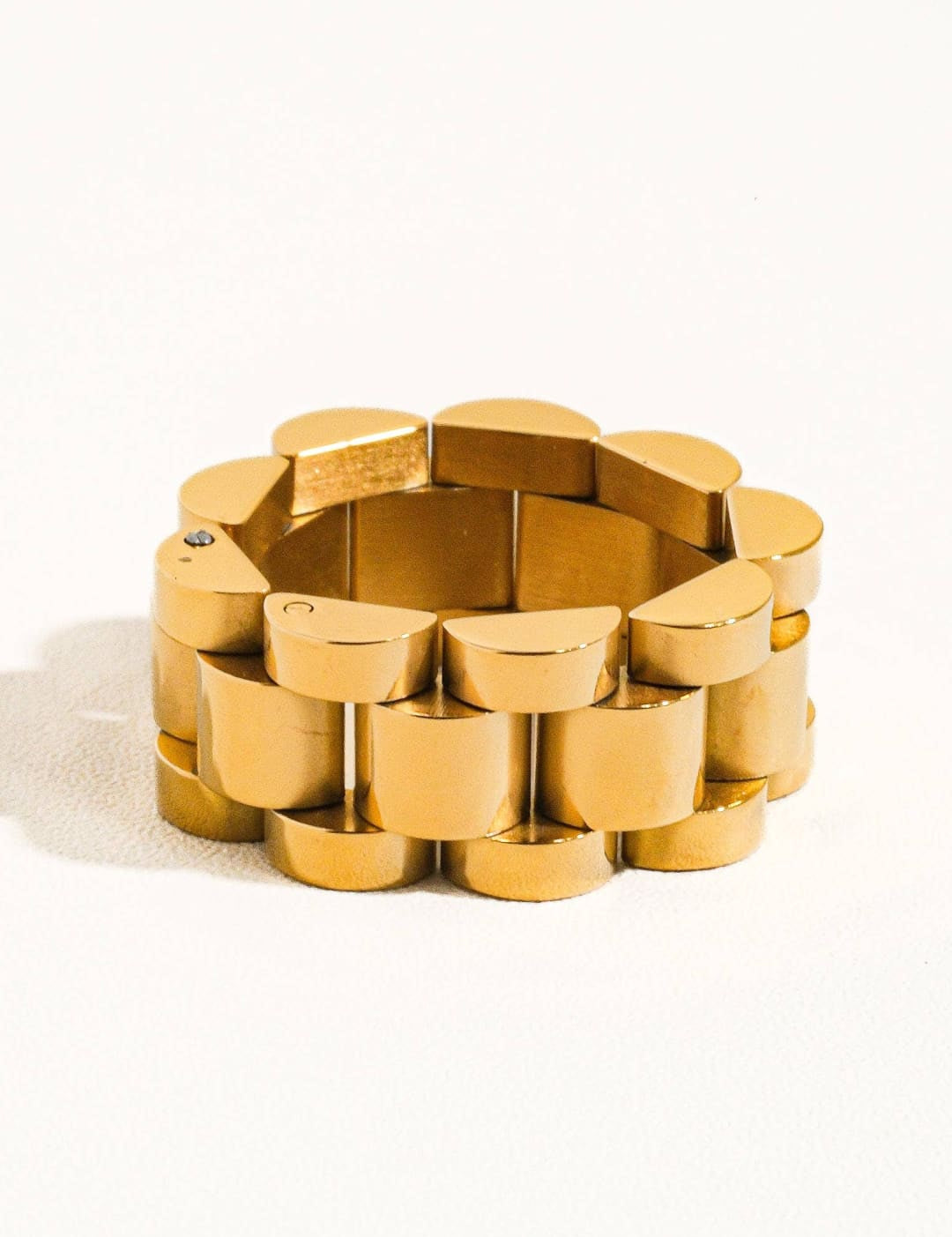 Gold-toned, interlocking link bracelet with a sleek, modern design.