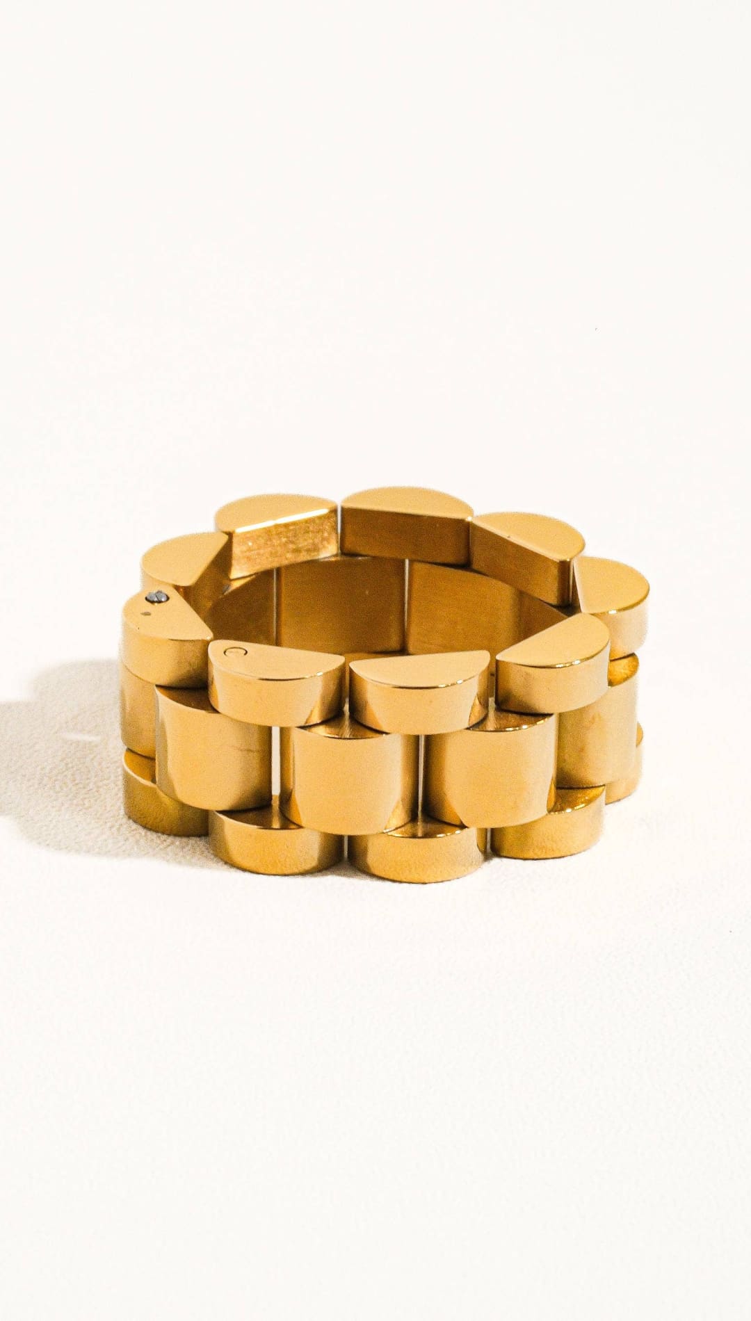 Gold-toned, interlocking link bracelet with a sleek, modern design.