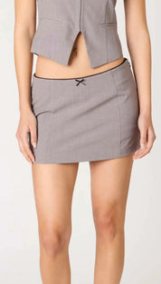 Gray mini skirt with a thin black trim and a small black bow.